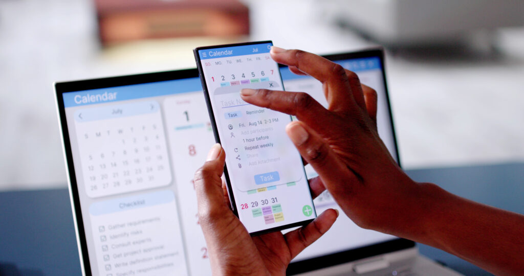 picture of hand holding smartphone with calendar open