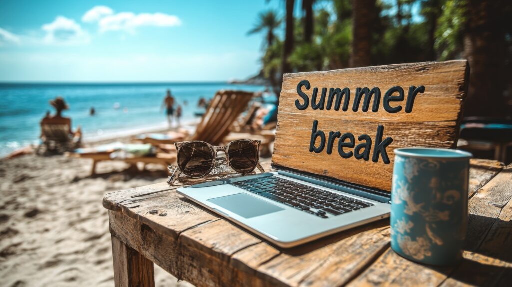 picture of laptop on beach with it open and a sign saying summer break.